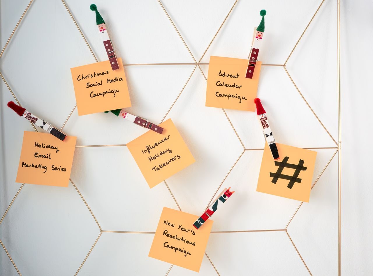 gallery-3 Sticky notes with holiday marketing ideas clipped to a wall grid.