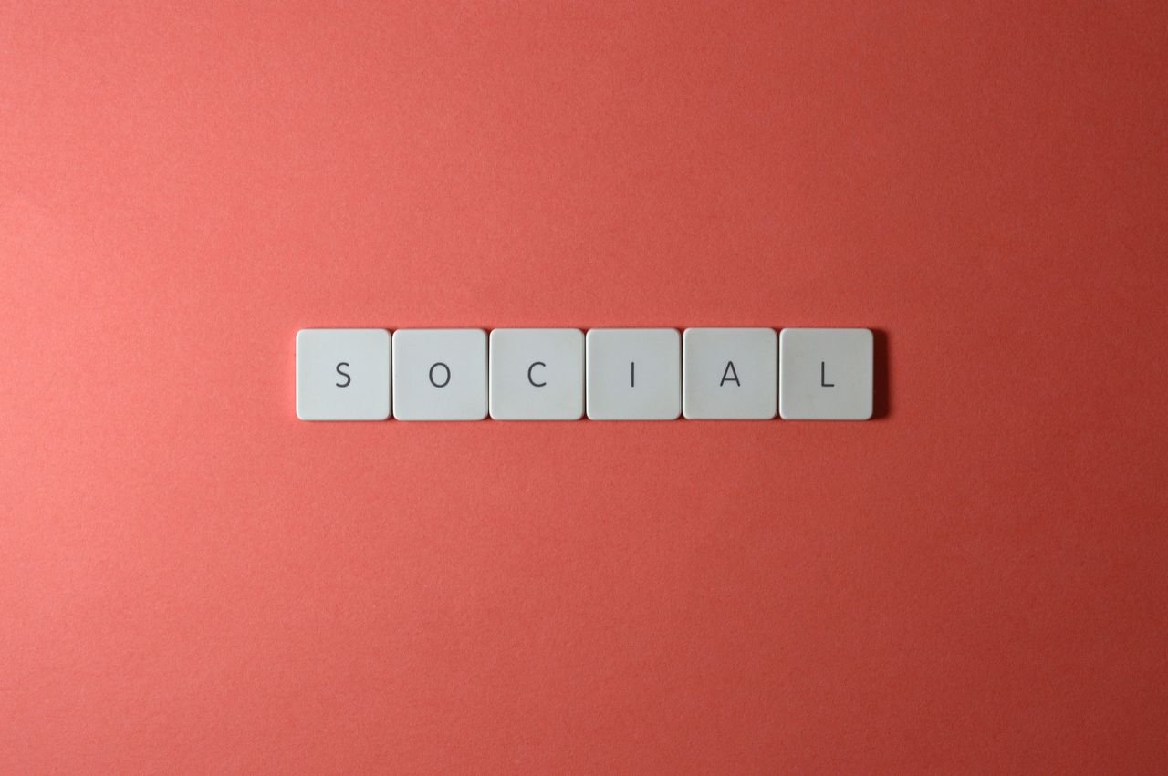gallery-3 Close-up of the word 'SOCIAL' formed with tiles on a red surface, offering copyspace.