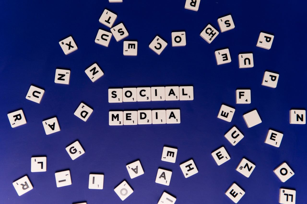 why-choose-us Scrabble tiles spelling 'Social Media' on a blue background, ideal for digital marketing themes.