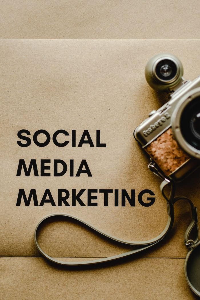 gallery-1 Close-up of a vintage camera next to a social media marketing concept text on a brown background.
