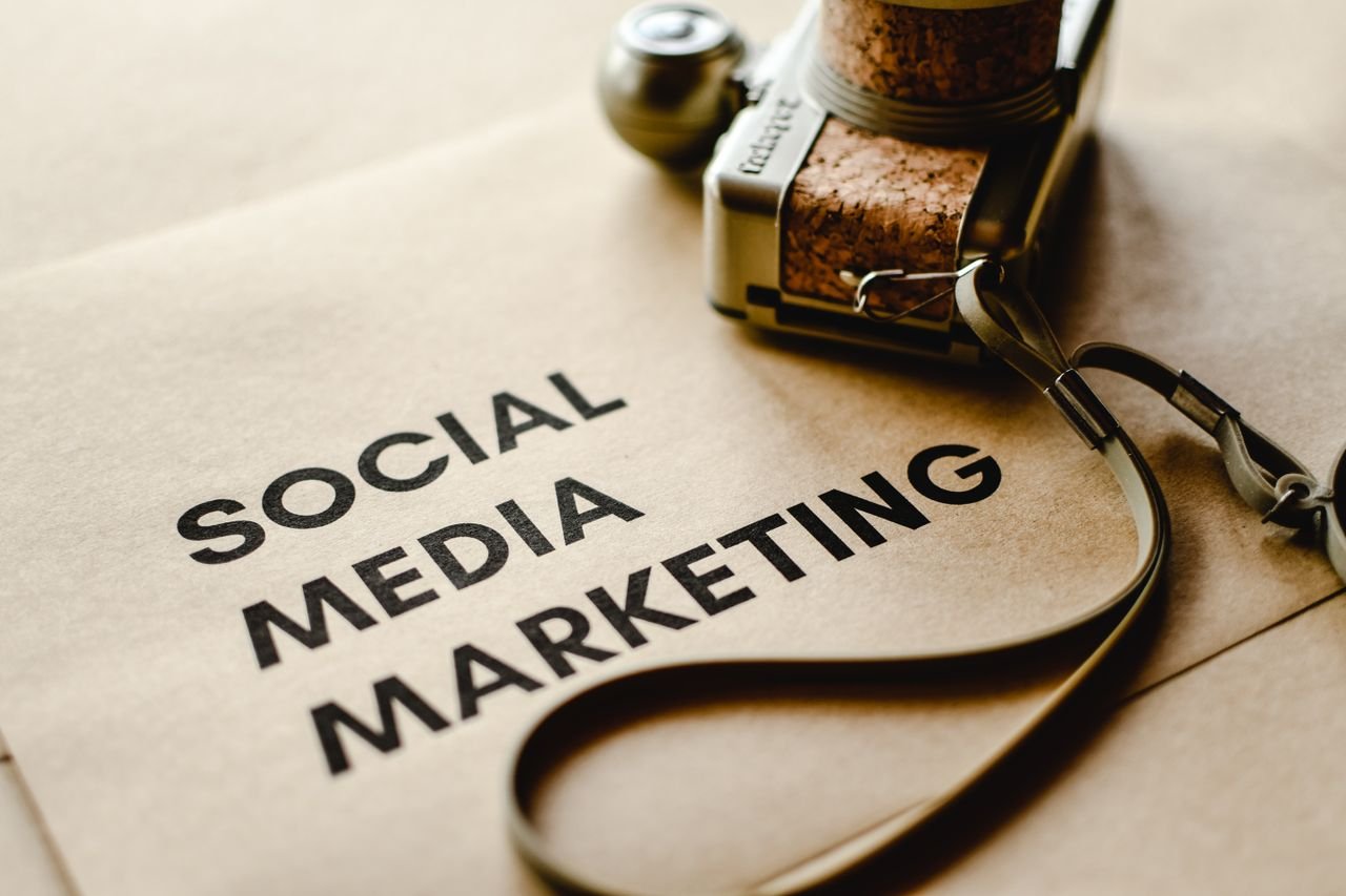 services-img Close-up of a camera placed on brown paper with 'Social Media Marketing' text, emphasizing digital marketing themes.
